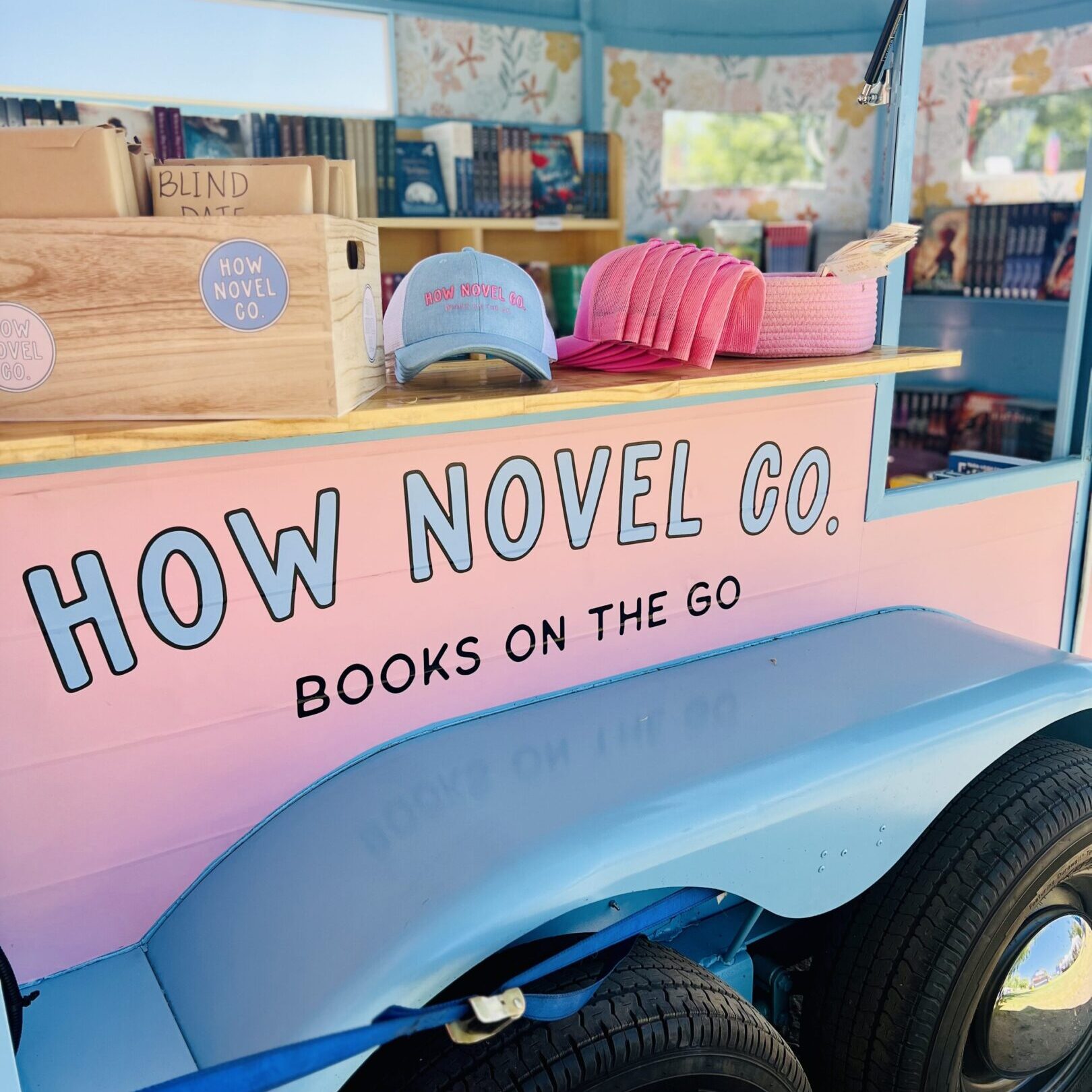 Pink and blue bookmobile labeled How Novel Co.